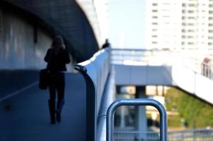 vrouw op loopbrug met telefoon foto