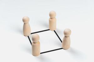 houten peg-poppen zijn verbonden met lijnen op een witte achtergrond. teamwork, leiderschap, business, human resource management concept foto