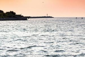 zee zonsondergang over pier, prachtig zeegezicht, dromen van reizen en vrijheid, boeien op zee, zonsondergang hemel en claim weer. foto