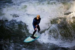 München, Duitsland - 23 oktober 2011 - niet-geïdentificeerde surfer in de eisbach-rivier in Engelse tuin in München, Duitsland op 23 oktober 2011. de eerste surfers ontdekten de eisbach in de jaren '70. foto