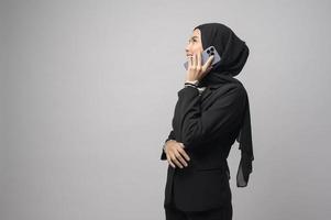 portret van mooie vrouw met hijab met behulp van mobiele telefoon op witte achtergrond foto