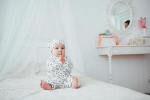 pasgeboren baby gekleed in een pak op een zacht bed in de studio. foto