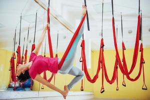 jonge mooie vrouw die yoga beoefent met een hangmat in de studio. foto