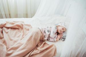 kind klein meisje slaapt in het bed foto