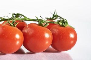 tak van rode biologische tomaten op een witte achtergrond foto