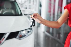 autosleutels doorgeven. bijgesneden close-up van een autohandelaar die autosleutels aan de camera standhoudt copyspace autodealer salon manager verkoper verkopen kopen geven eigenaar beroep aankoop voertuig concept foto