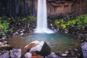 geweldig uitzicht op de svartifoss-waterval. dramatische en pittoreske scène. populaire toeristische attractie. IJsland foto