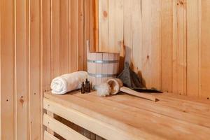 traditioneel oud russisch badhuis spa concept. interieur details Finse sauna stoomkamer met traditionele sauna accessoires set wastafel handdoek aroma olie schep vilt. ontspannen land dorp bad concept. foto