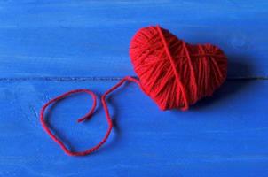 close-up van rode hartvorm gemaakt van draadgaren op blauw houten voor Valentijnsdag achtergronden met foto