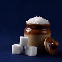 suiker. witte kristalsuiker en geraffineerde suiker op een blauwe achtergrond foto