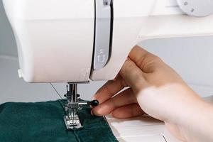 vrouw ontwerper of kleermaker bezig met naaimachine. foto