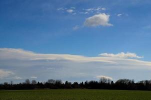 groen veld en zachte wolken foto