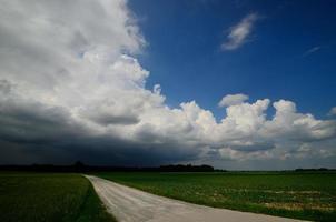 onverharde weg met zwarte wolken foto