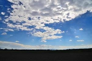 lucht met witte wolken op veld foto