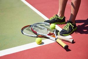 een tennisracket en nieuwe tennisbal op een pas geschilderde tennisbaan foto