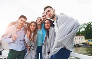 lachende gelukkige groep vrienden poseren voor de camera buiten op de strandpier foto