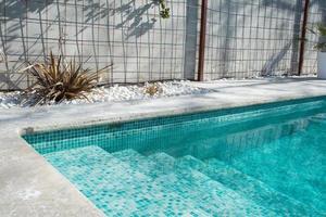 privé zwembad met trappen om in te komen. transparant water. betonnen muren rondom. Spanje foto