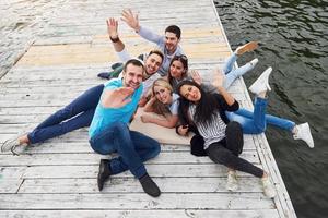 groep mooie jonge mensen op de pier, tevredenheid van vrienden zorgt voor emotioneel leven foto