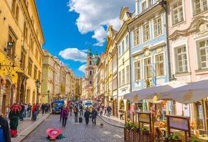 praag, tsjechische republiek, 13 mei 2019 mensen lopen door straat in mindere stad, gebouwen met oude kleurrijke gevels foto