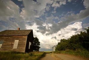 onweerswolken achter een oude boerderij in Saskatchewan foto