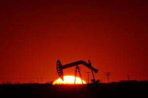 oliepomp in het veld van Saskatchewan bij zonsondergang foto