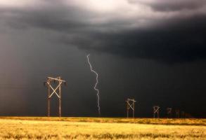 blikseminslag achter de hoogspanningslijn van Saskatchewan foto