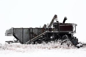 verlaten antieke dorsmachine in de winter foto