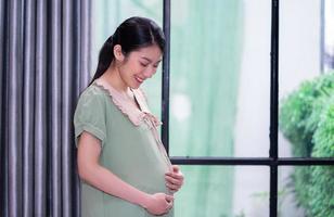 jonge Aziatische vrouw zwanger ontspannen thuis foto