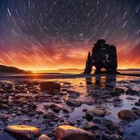 sterrenhemel in een spectaculaire rots in de zee aan de noordkust van ijsland. legendes zeggen dat het een versteende trol is foto