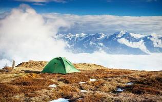 tent tegen de achtergrond van besneeuwde bergtoppen. het uitzicht vanaf de bergen naar de berg ushba mheyer, georgië. Europa foto