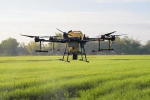 landbouwdrone vliegt en sproeit kunstmest en pesticiden over landbouwgrond, geavanceerde technologische innovaties en slimme landbouw foto