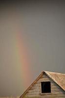 regenboog die neerdaalt achter het oude gebouw in Saskatchewan foto