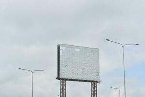 oud leeg reclamebord roestvrij tegen blauwe hemelachtergrond voor reclame of ontwerp. foto