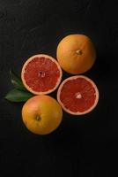 verse, sappige grapefruit diagonaal gegroepeerd. rijpe citrus op zwarte achtergrond. foto