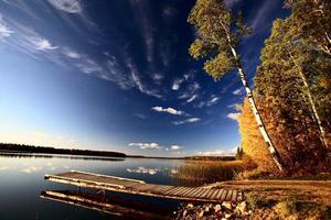 aanlegsteiger en herfstbomen langs een meer van Saskatchewan foto