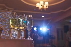 veel wijnglazen in blauw licht met een koele heerlijke champagne of witte wijn aan de bar foto