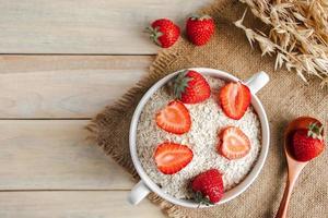 Havermuesli en verse aardbeien op houten achtergrond foto