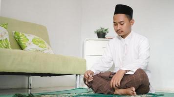 Aziatische moslim man doet dhikr foto