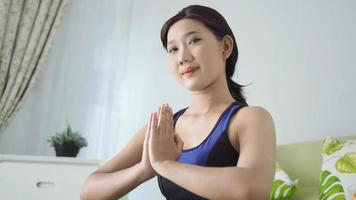 Aziatische vrouw yoga thuis handoefeningen doen met focus foto