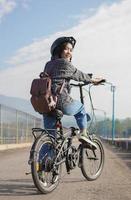 jonge aziatische vrouw pauzeert de fiets voordat ze naar het werk gaat foto