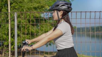 jonge aziatische vrouw die geniet van fietsen in de zomerochtend foto