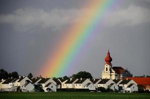 regenboog in dorp met kerk foto