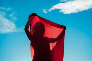 vrouw gewikkeld in een rode sjaal in de wind foto