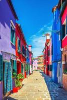 burano, italië, 14 september 2019 burano eiland smalle geplaveide straat tussen kleurrijke huizen foto