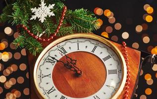gelukkig nieuwjaar om middernacht 2018, oude houten klok met vakantieverlichting en dennentakken foto