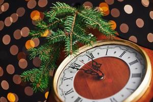 gelukkig nieuwjaar om middernacht 2018, oude houten klok met vakantieverlichting en dennentakken foto