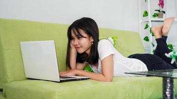 mooie aziatische vrouwen die vanuit huis werken met behulp van laptop en slapen op een stoel foto
