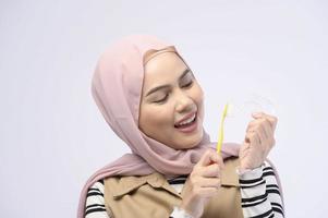 een jonge moslimvrouw die tandenborstel met mooie tanden gebruikt, tandheelkundig zorgconcept foto
