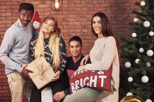 multiculturele vrienden die samen thuis rusten op kerstavond foto