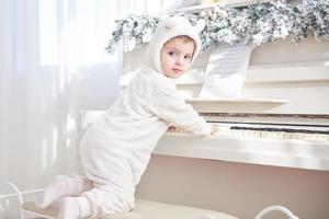 gelukkig klein meisje speelt piano op eerste kerstdag foto